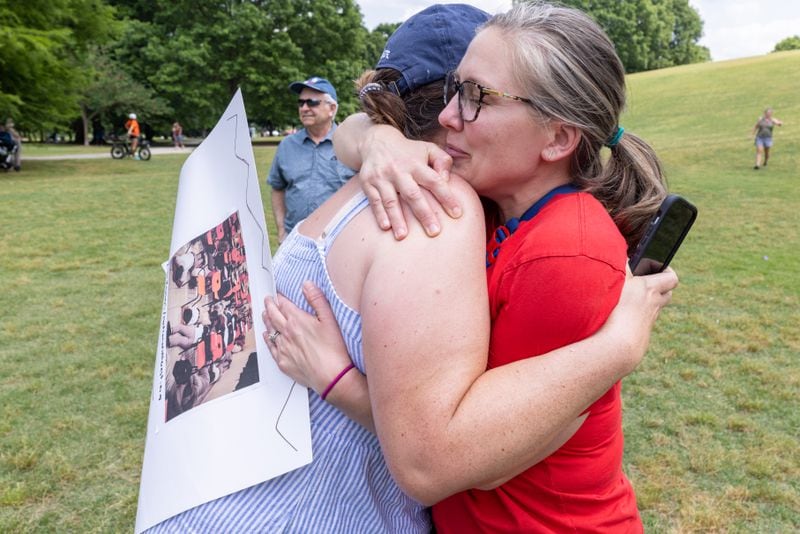Alyssa Morrison (Left) and Stephanie Dill hug during a rally organized by Georgia Moms Demand Action in Piedmont Park Saturday, May 13, 2023. Dill said the conversation became emotional when she recounted the time her child was involved in a school lockdown in Atlanta.   (Steve Schaefer/steve.schaefer@ajc.com)