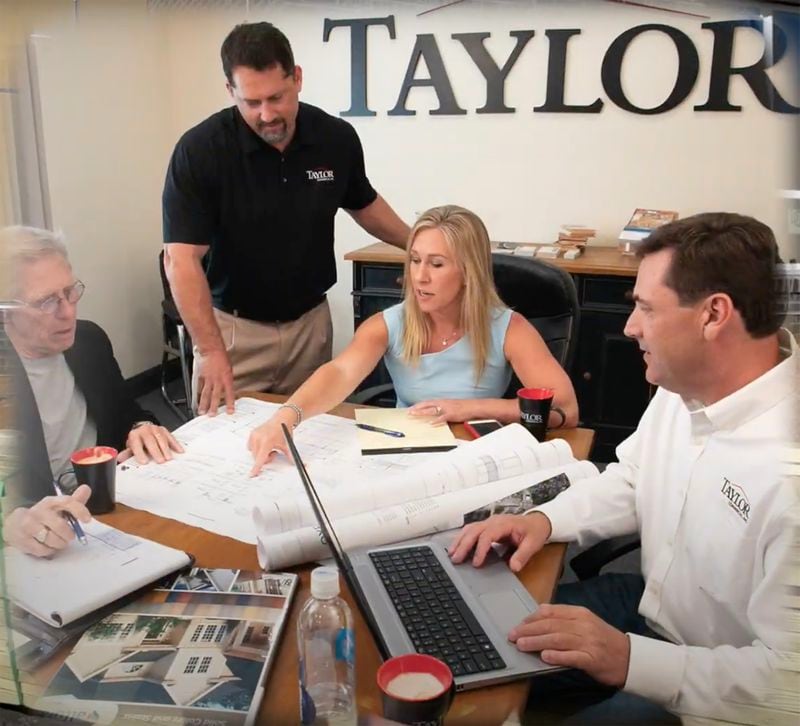 Majorie Taylor Greene says she and her husband purchased the family business, Taylor Commercial, Inc., from her father in 2002. This image from a campaign ad last year shows Greene, her husband, Perry, (standing) and her father, Robert Taylor, (left) at the company's North Fulton offices. The company for years has marketed its work in affordable housing projects.