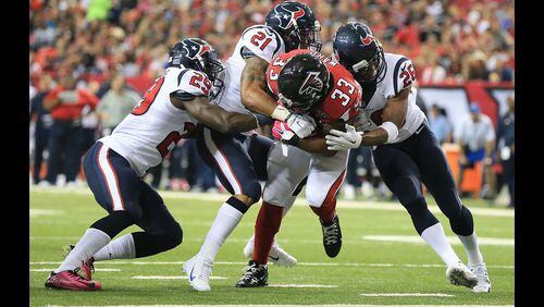 Falcons running back Terron Ward bulls his way through Texans defenders Andre Hall (from left), Darryl Morris, and Rahim Moore into the endzone for a touchdown and a 42-0 lead during the third quarter in a football game on Sunday, Oct. 4, 2015, in Atlanta. The Falcons beat the Texans 48-21. (Curtis Compton/ccompton@ajc.com)