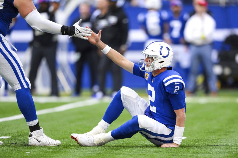 Indianapolis Colts quarterback Matt Ryan (2) gets help off the ground after getting hit during an NFL football game against the Jacksonville Jaguars, Sunday, Oct. 16, 2022, in Indianapolis. (AP Photo/Zach Bolinger)
