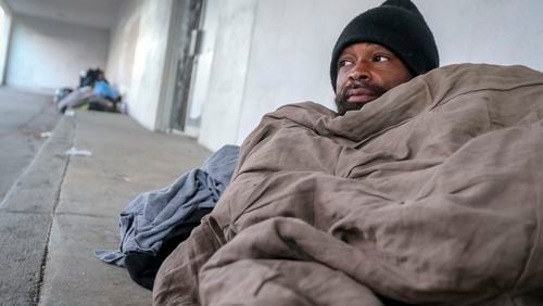 In January, Antwan Slaton bundled up as best he could in Atlanta as temperatures dropped into the teens. Slaton spent the night on a concrete sidewalk outside the South Rhodes Center in Midtown. (John Spink / John.Spink@ajc.com)