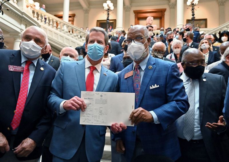Gov. Brian Kemp and state Rep. Calvin Smyre hold House Bill 426, hate-crimes legislation, after the governor signed it into law in 2020 following the fatal shooting of Ahmaud Arbery. (Hyosub Shin / Hyosub.Shin@ajc.com)
