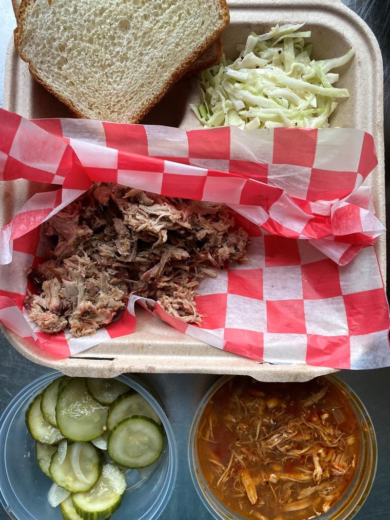 BBQ Cafe’s pulled pork plate comes with slaw, Brunswick stew and a side of house-made bread-and-butter pickles. Wendell Brock for The Atlanta Journal-Constitution