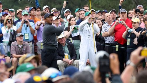 With patrons around him, Tiger Woods tees off on the eighth hole during the practice round of the 2024 Masters Tournament at Augusta National Golf Club, Tuesday, April 9, 2024, in Augusta, Ga. (Jason Getz / jason.getz@ajc.com)