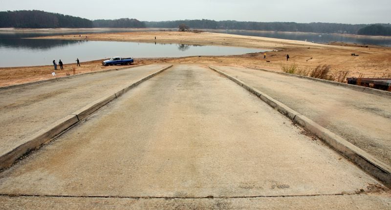 CUMMING, GA: This photo from late 2007 shows a vast area of usually water-covered boat ramp borders the also usually water-covered areas of Lake Lanier as volunteers scour the drought-revealed lake bottom for trash and debris at Mary Alice Park in Cumming, GA. The 2007 drought pushed Lake Lanier way below its full-pool level of 1071 feet. (Kimberly Smith/staff)