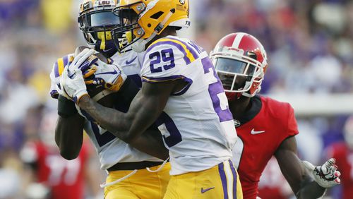 10/13/18 - Baton Rouge -  LSU Tigers safety John Battle (26), with assistance from  LSU Tigers cornerback Greedy Williams (29),  intercepts a  Georgia Bulldogs quarterback Jake Fromm pass intended for Georgia Bulldogs wide receiver Jeremiah Holloman (9) late in the 4th quarter to seal the Tigers victory.  The Tigers won 36-16.   The University of Georgia Bulldogs played the Louisiana State University Tigers in a NCAA college football game Saturday, October 13, 2018, at Tiger Stadium in Baton Rouge, LA.    BOB ANDRES / BANDRES@AJC.COM