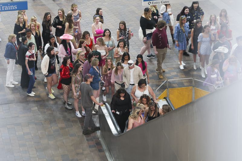 Fans of Taylor Swift wait to ride an escalator out of the GWCC MARTA station as they move toward Mercedes-Benz Stadium before the Taylor Swift concert Friday in Atlanta. 
