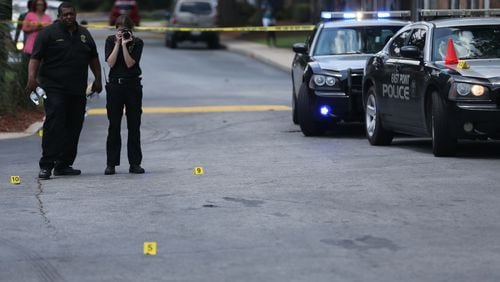 East Point police process the scene of a July 20, 2015, triple shooting that left two teenagers wounded and another dead. BEN GRAY / BGRAY@AJC.COM