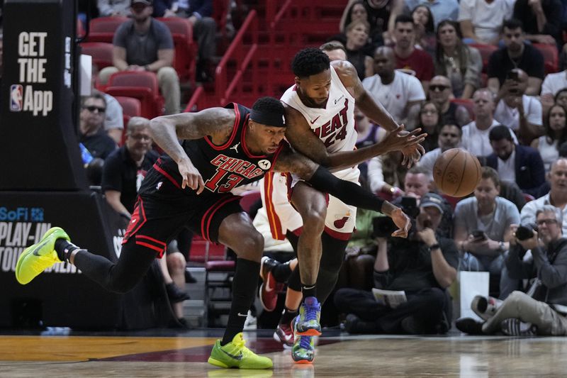 Chicago Bulls forward Torrey Craig (13) and Miami Heat forward Haywood Highsmith (24) battle for a loose ball during the first half of an NBA basketball play-in tournament game, Friday, April 19, 2024, in Miami. (AP Photo/Wilfredo Lee)