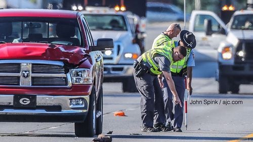 Georgia State Patrol troopers investigate after a police said an asphalt worker was hit by a red Dodge pickup truck and killed on Tara Boulevard on Tuesday morning.