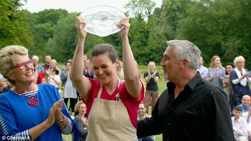 Sophie Faldo, seen with judges Prue Leith (left) and Paul Hollywood, holds up the crystal cake stand that was her prize for winning the 2017 “Great British Baking Show.” (Courtesy of Channel 4)
