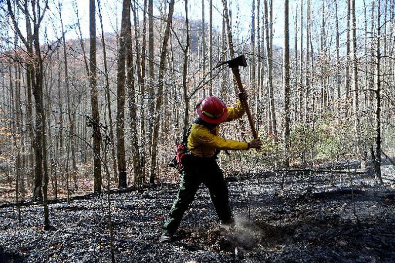 Firefighter Cody Henderson, who is from New Mexico, works on structure protection and putting out hot spots on Tallulah River Road near the Georgia-North Carolina border. CURTIS COMPTON / CCOMPTON@AJC.COM
