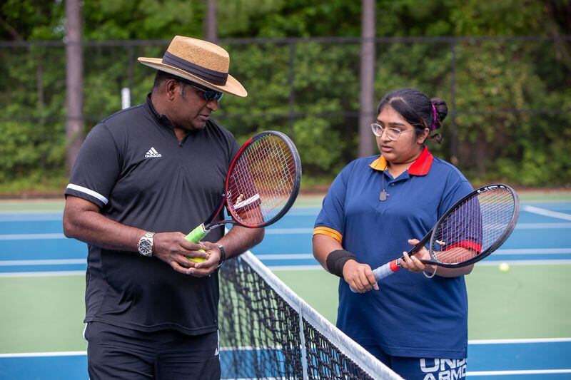 Tennis instructor Francis Ali talks to daughter Brianna during a session at the Lucky Shoals Park tennis courts in Norcross. Phil Skinner/For The Atlanta Journal-Constitution