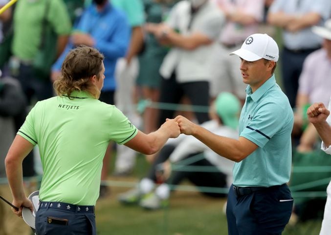 April 9, 2021, Augusta: Cameron Smith, left, and Jordan Spieth fist bump as they finish their second round on the eighteenth green during the Masters at Augusta National Golf Club on Friday, April 9, 2021, in Augusta. Curtis Compton/ccompton@ajc.com