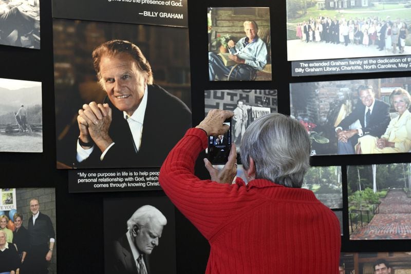 Lyn Warwick of Black Mountain, N.C., photographs a memorial display of the Rev. Billy Graham inside Chatlos Chapel at the Billy Graham Training Center at the Cove on Wednesday, Feb. 21, 2018, in Asheville, N.C. Warwick is friends with Gigi Graham, Billy Graham’s daughter. (AP Photo/Kathy Kmonicek)