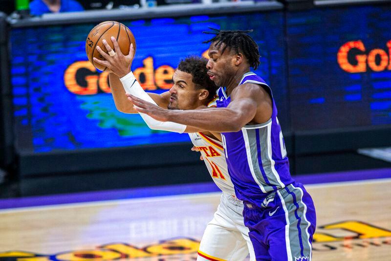 Atlanta Hawks guard Trae Young (11) is fouled by Sacramento Kings guard Buddy Hield during the first quarter of an NBA basketball game in Sacramento, Calif., Wednesday, March 24, 2021. (AP Photo/Hector Amezcua)