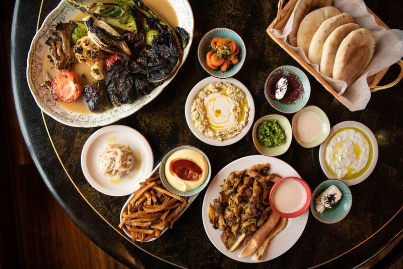 Nur Kitchen Mezze Plate, Seasonal Vegetable Plate, and Chicken Shawarma Platter with side of fries and mango aioli dipping sauce. (Mia Yakel for The Atlanta Journal-Constitution)