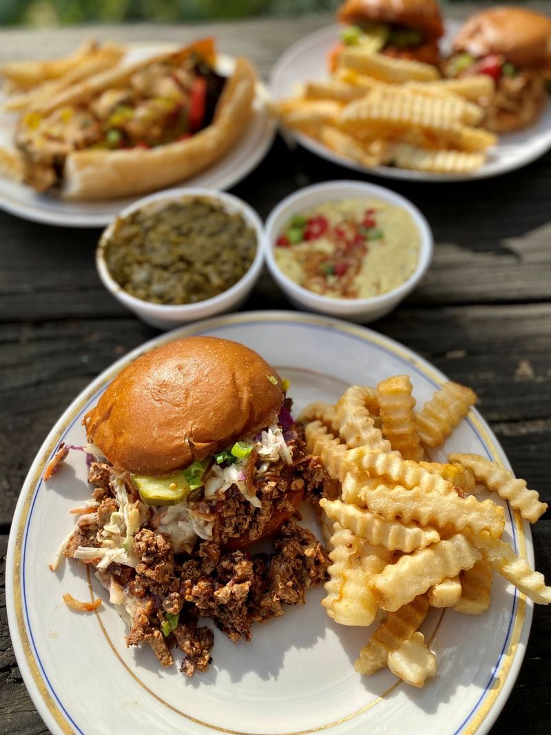 Grass VBQ Joint offers vegan mock-meat barbecue, like the Titustown. In the background are vegan potato salad, collards cooked in coconut milk and some other sandwiches with fries. Wendell Brock for The Atlanta Journal-Constitution