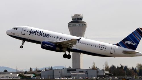 FILE - In this April 23, 2013, file photo, a JetBlue plane takes off in view of the air traffic control tower at Seattle-Tacoma International Airport, in Seattle. (AP Photo/Elaine Thompson, File)