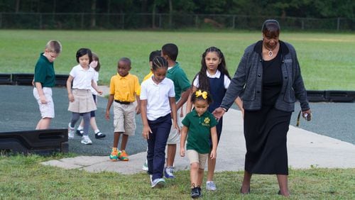 Elementary school principal Dr. Cassandra Hopkins leads the students in from the playground after a portrait session about school uniforms Wednesday, August 2, 2015, at McGarrah Elementary School in Morrow, GA. STEVE SCHAEFER / SPECIAL TO THE AJC