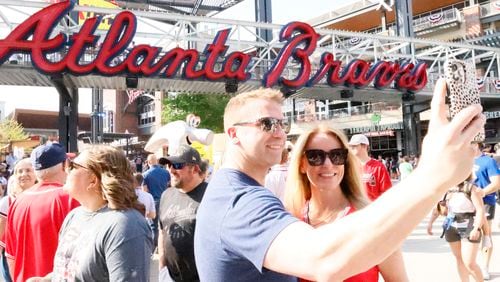 Rob Crump takes a selfie with Linnea Forge in front of the giant Braves sign at The Battery before the Brave’s home opener at Truist Park on Thursday, April 6, 2023.
Miguel Martinez /miguel.martinezjimenez@ajc.com