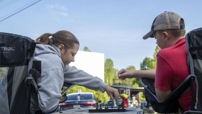Tiger, Georgia - Siblings Tillie Crumley, 16, (left) and Shepard Crumley, 11, (right) play a game of chess before the start of the movie at the Tiger Drive-In movie theater in Tiger, Friday, May 22, 2020. This was the family’s first time at the theater. (ALYSSA POINTER / ALYSSA.POINTER@AJC.COM)