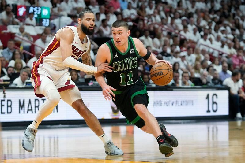 Boston Celtics guard Payton Pritchard (11) drives to the basket past Miami Heat forward Caleb Martin (16) during the first half of Game 3 of an NBA basketball first-round playoff series, Saturday, April 27, 2024, in Miami. (AP Photo/Wilfredo Lee)