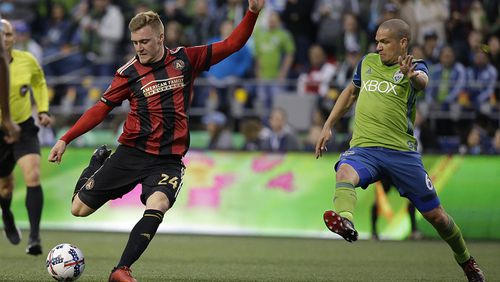 Atlanta United midfielder Julian Gressel, left gets a shot on goal off under pressure from Seattle Sounders midfielder Osvaldo Alonso, right, in the first half of an MLS soccer match, Friday, March 31, 2017, in Seattle. (AP Photo/Ted S. Warren)