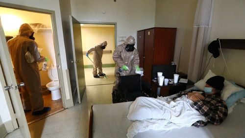 Members of the Georgia Army National Guard  disinfect a resident's room at the Legacy Transitional Care last month in Atlanta.