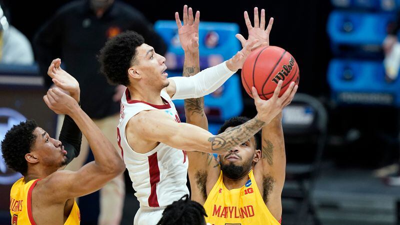 Alabama's Jahvon Quinerly, center, scores ahead of Maryland's Aaron Wiggins (2) and Eric Ayala, right, during the first half of a college basketball game in the second round of the NCAA tournament at Bankers Life Fieldhouse in Indianapolis Monday, March 22, 2021. (AP Photo/Mark Humphrey)