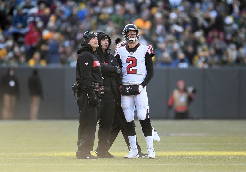 GREEN BAY, WISCONSIN - DECEMBER 09: Matt Ryan #2 of the Atlanta Falcons talks with head coach Dan Quinn and offensive coordinator Steve Sarkisian during the first half of a game against the Green Bay Packers at Lambeau Field on December 09, 2018 in Green Bay, Wisconsin. (Photo by Stacy Revere/Getty Images)