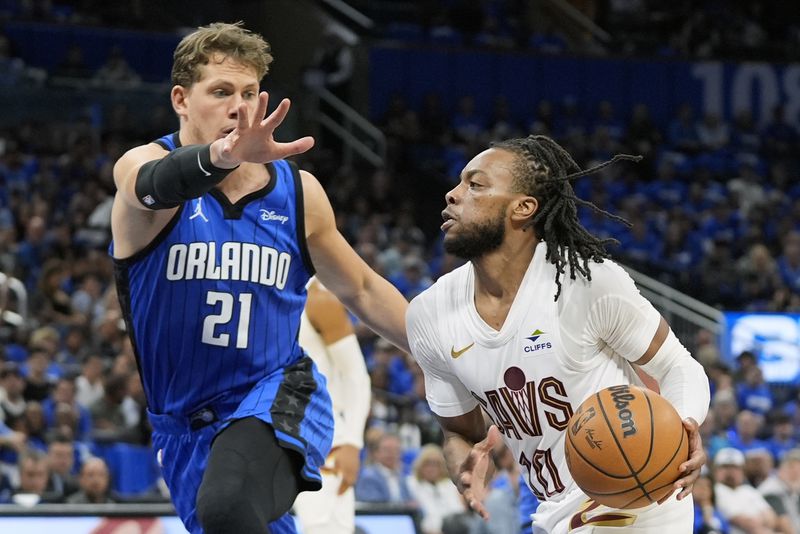 Cleveland Cavaliers guard Darius Garland, right, drives past Orlando Magic center Moritz Wagner (21) during the first half of Game 6 of an NBA basketball first-round playoff series, Friday, May 3, 2024, in Orlando, Fla. (AP Photo/John Raoux)