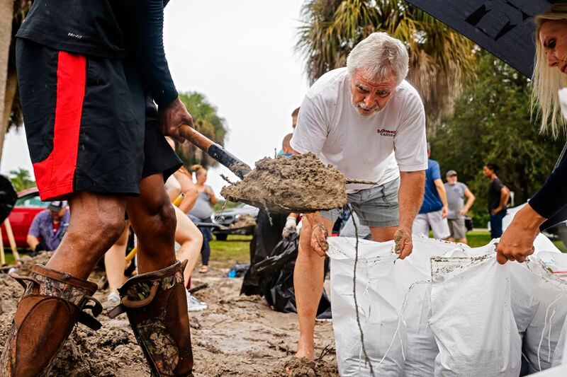 John Lam helps fill sand bags for his home in North Port, Fla., in preparation for Hurricane Ian, on Tuesday Sept. 27, 2022.(Scott McIntyre/The New York Times)