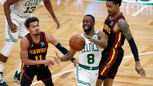 Atlanta Hawks' John Collins, right, fouls Boston Celtics' Kemba Walker (8) as Trae Young (11) defends during the second half of an NBA basketball game Friday, Feb. 19, 2021, in Boston.