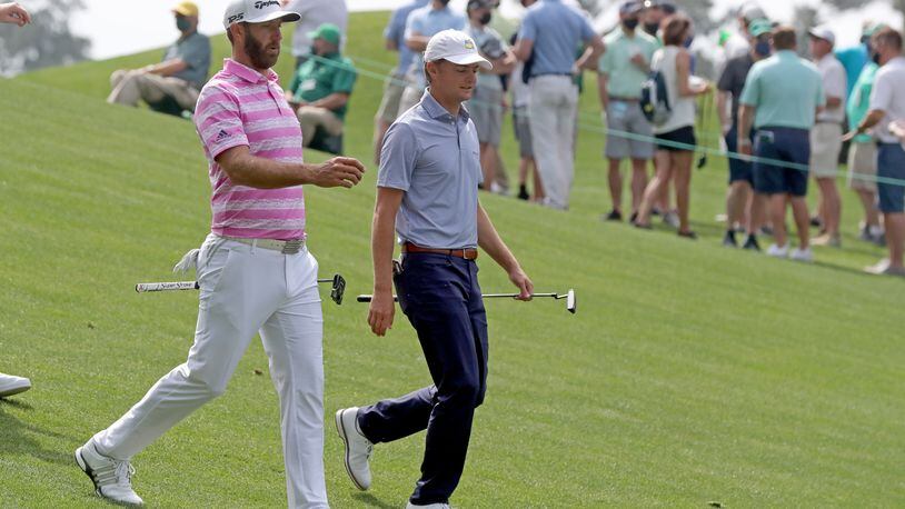 Defending Masters champion Dustin Johnson and former Georgia Tech golfer Tyler Strafaci walk to the fourth hole after their tee shots during the first round of the Masters at Augusta National Golf Club on Thursday, April 8, 2021, in Augusta. Curtis Compton/ccompton@ajc.com