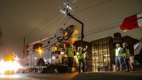 Crews work to make repairs after crash causes power pole to snap and fold over early Friday morning.