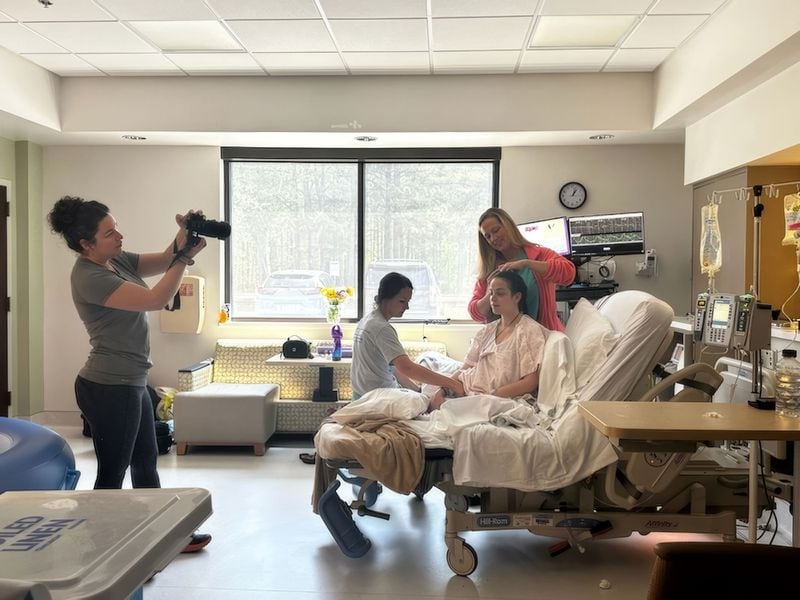 Midwife Carson Ragan (top right) and doula and photographer Maegan Hall (far left) assist and document a birth.
(Courtesy of Aaron Schulke)