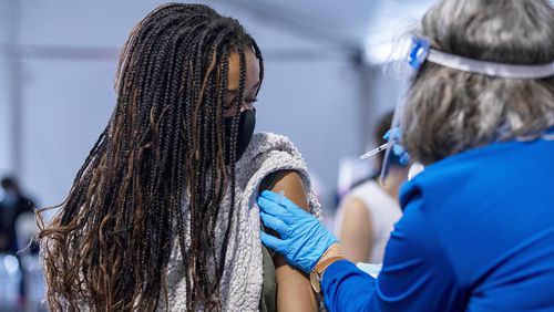 Brookhaven resident Jordan Ricketts, 21, receives a COVID-19 vaccine shot at a DeKalb Board of Health COVID-19 vaccination site at the Doraville MARTA transit station on Monday. (Alyssa Pointer / Alyssa.Pointer@ajc.com)