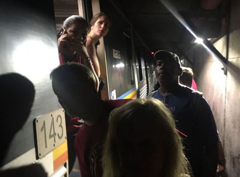 Passengers get off a train during lengthy delays Wednesday night on MARTA.