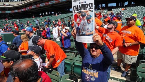 ARLINGTON, TX - MARCH 29:  A Houston Astros fan holds up a newspaper cover with a photo from the World Series as the team starts batting practice before the Opening Day game agaisnt the Texas Rangers at Globe Life Park in Arlington on March 29, 2018 in Arlington, Texas.  (Photo by Richard Rodriguez/Getty Images)