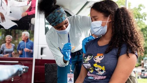 Ashanti Booker, a registered nurse with the DeKalb County Board of Health, gives a Covid-19 vaccination to Raya High, 13, at a mobile clinic at Decatur High School on  July 19, 2021. Ben Gray for the Atlanta Journal-Constitution