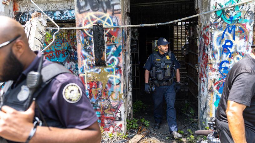 Officers walk out of an old prison farm building during an Atlanta Police Department and Atlanta Fire Rescue media tour of the Atlanta Public Safety Training Center site on Friday, May 26, 2023. (Arvin Temkar / arvin.temkar@ajc.com)