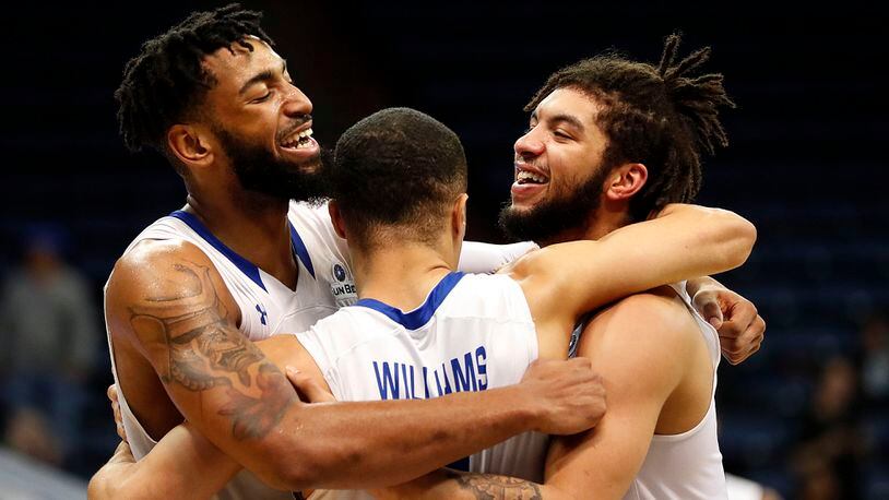 Georgia State forward Jordan Session, left, guard D'Marcus Simonds, right, and guard Isaiah Williams, center, celebrate in the final minute of the second half in their victory over Texas-Arlington in the the Sun Belt Conference NCAA college basketball championship game in New Orleans, Sunday, March 11, 2018. Georgia State won 74-61. (AP Photo/Gerald Herbert)