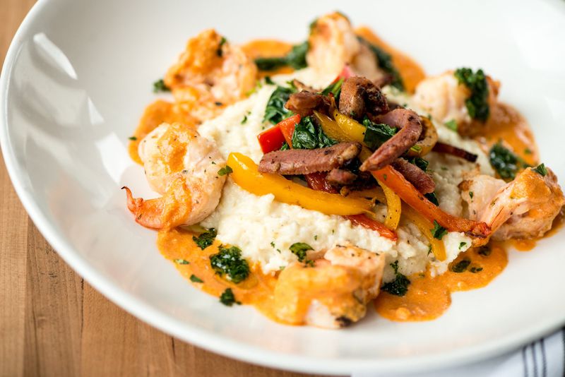  Shrimp and Grits with creamy cheese grits, spinach, tasso, bell peppers, and smoked tomato cream. Photo credit- Mia Yakel.