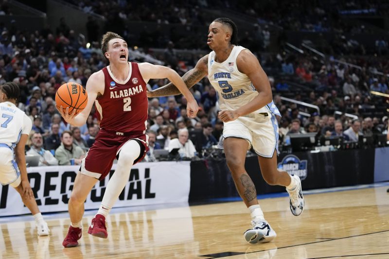 Alabama forward Grant Nelson (2) dribbles past North Carolina forward Armando Bacot (5) during the second half of a Sweet 16 college basketball game in the NCAA tournament Thursday, March 28, 2024, in Los Angeles. (AP Photo/Ashley Landis)