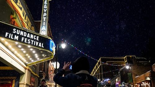 People take photos beneath the marquee of the Egyptian Theater during the Sundance Film Festival on Jan. 22, 2020, in Park City, Utah. (Kent Nishimura/Los Angeles Times/TNS)
