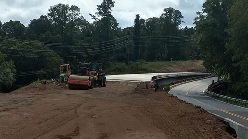 The bridge platform was in place and work had begun to smooth the ground where the new roadway will be built to connect Arnold Mill Road with the new bridge. Photo taken Aug. 19, 2018. (Brian O'Shea / bposhea@ajc.com)