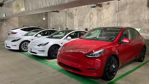This photo provided by Edmunds shows a line of parked Tesla Model 3 and Model Y vehicles. The shopping and research process when buying your first used Tesla can be more involved than what's required for a typical gas-powered car. (Courtesy of Edmunds via AP)