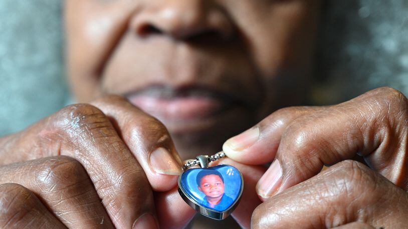 Glenda Mack holds a necklace that includes a photo of her grandson David. The 12-year-old was found shot to death in February, not far from their southwest Atlanta home.