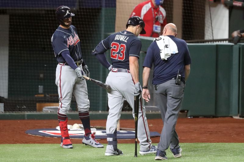 Braves outfielder Nick Markakis (left) taps left fielder Adam Duvall (23) as he leaves the game after he was injured on a swing during the second inning against the Los Angeles Dodgers Monday, Oct. 12, 2020, at Globe Life Field in Arlington, Texas. (Curtis Compton / Curtis.Compton@ajc.com)

